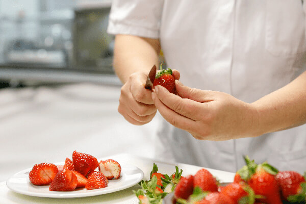 Mitarbeiter beim Schneiden von Erdbeeren